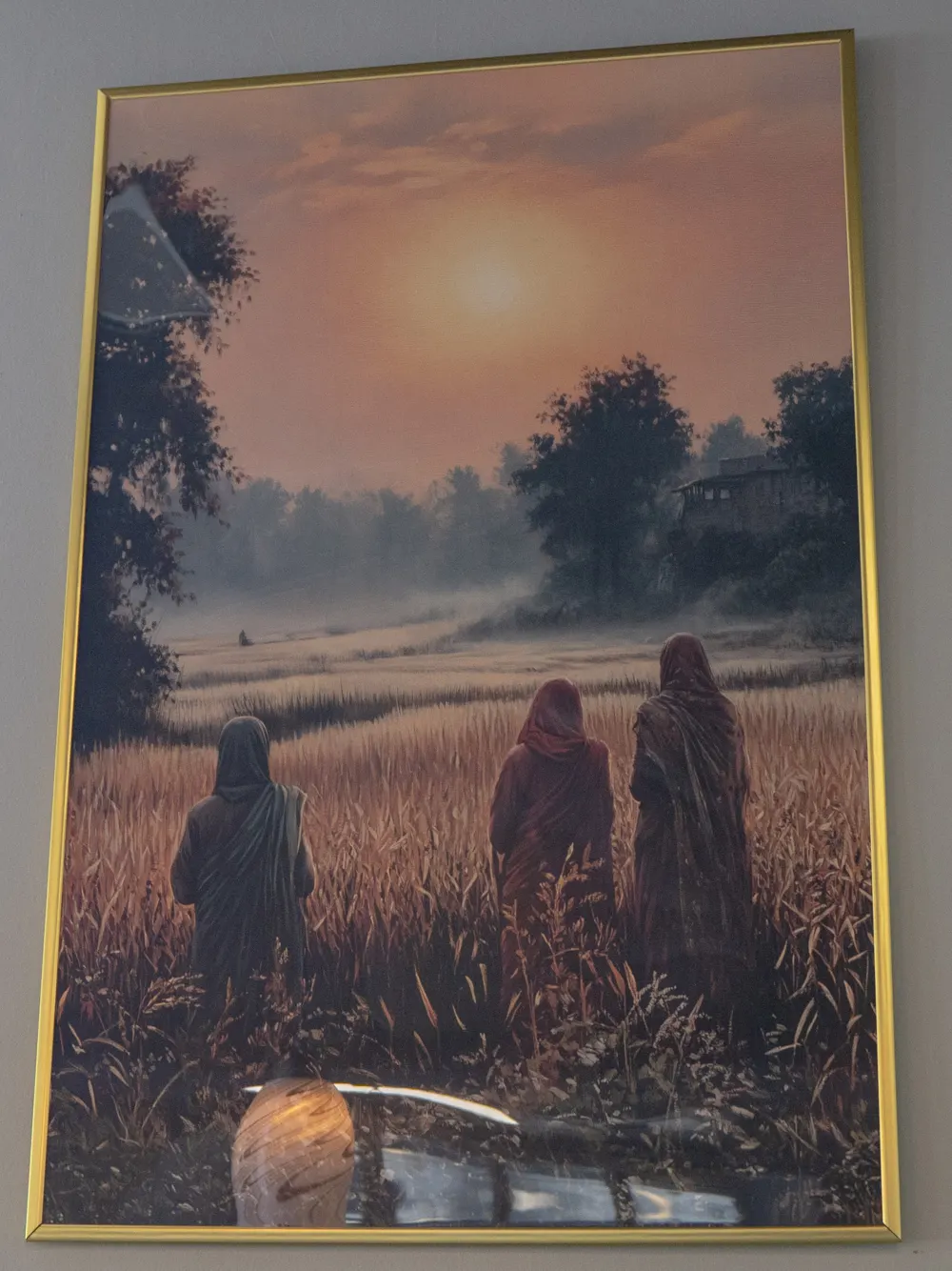 Painting of women walking through golden fields at sunrise, in the Mehfil dining room